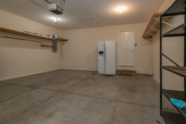 175 Mesquite Dr, Branson, MO 65616 - garage with white refrigerator with ice dispenser and a garage door opener