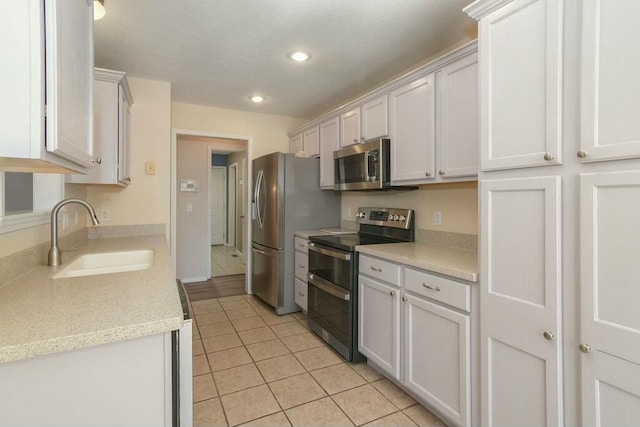175 Mesquite Dr, Branson, MO 65616 - kitchen featuring light countertops, light tile patterned floors, stainless steel appliances, white cabinetry, and a sink