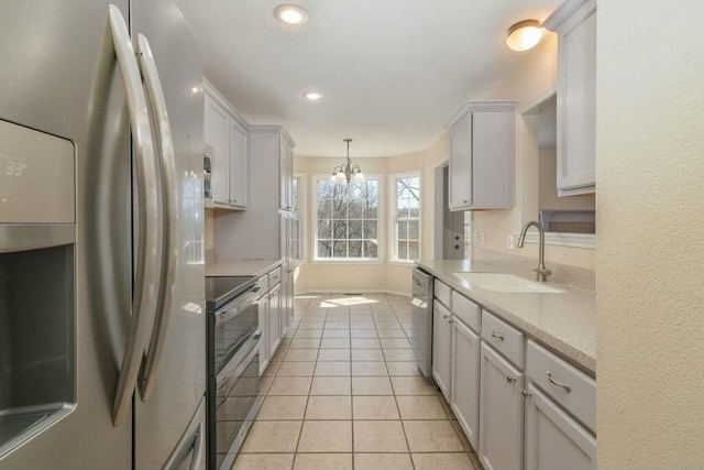 175 Mesquite Dr, Branson, MO 65616 - kitchen with a chandelier, light countertops, light tile patterned floors, appliances with stainless steel finishes, and a sink