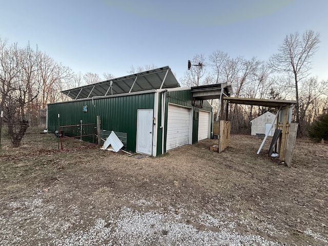 view of outdoor structure with a carport, an outbuilding, and driveway