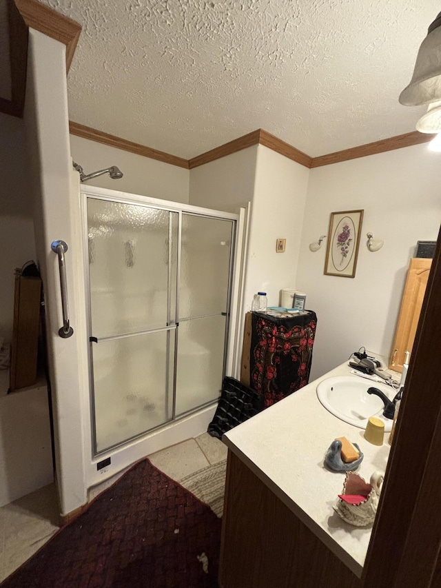 full bathroom featuring vanity, crown molding, a stall shower, and a textured ceiling