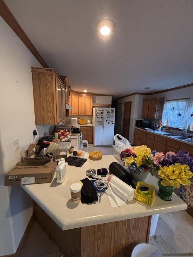 kitchen with ornamental molding, a peninsula, light countertops, and white fridge with ice dispenser