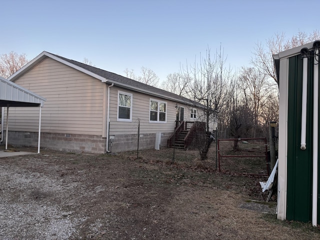 view of side of home featuring crawl space and fence