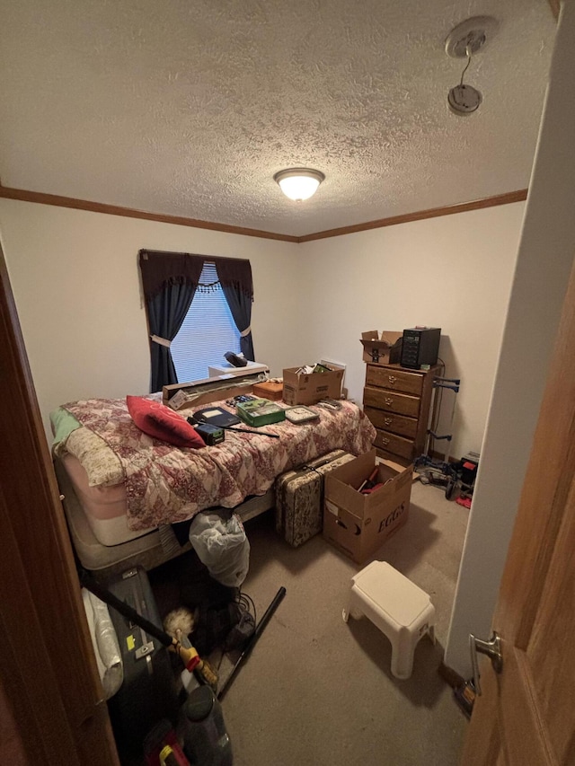 bedroom featuring a textured ceiling, crown molding, and carpet