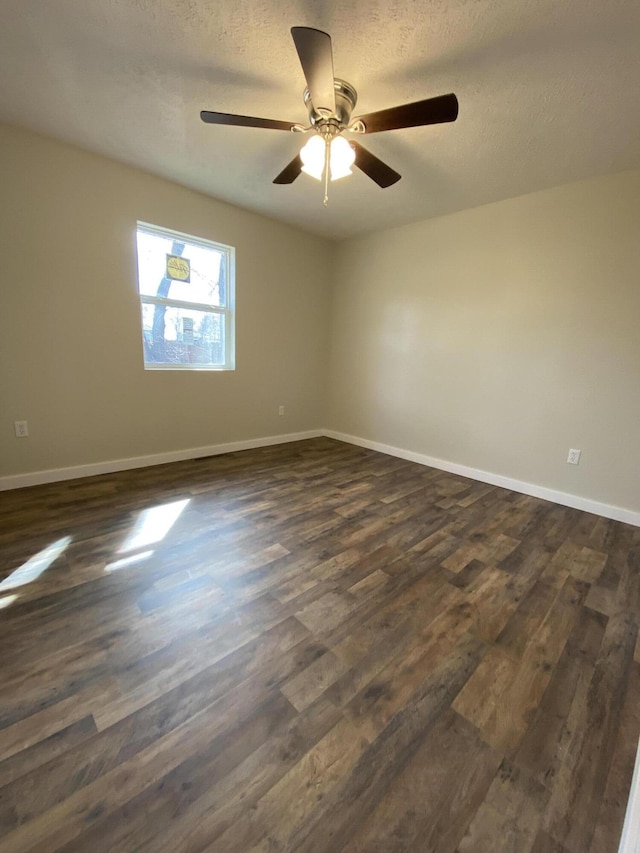 unfurnished room featuring dark wood finished floors, a ceiling fan, baseboards, and a textured ceiling