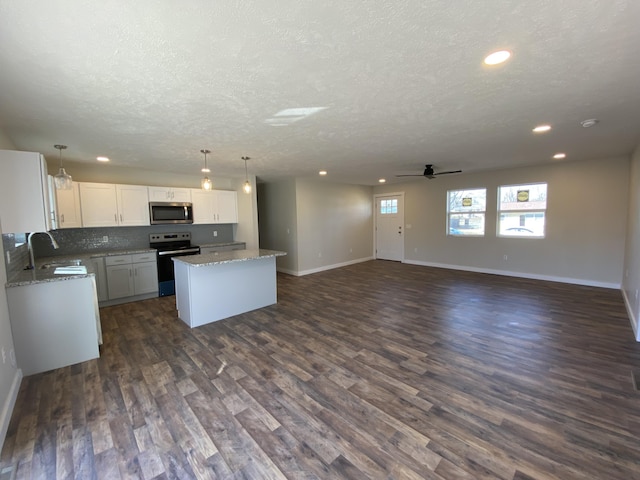 kitchen with a sink, a center island, dark wood-style flooring, and stainless steel appliances