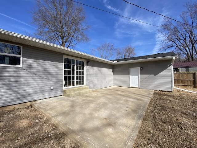 rear view of house with a patio and fence