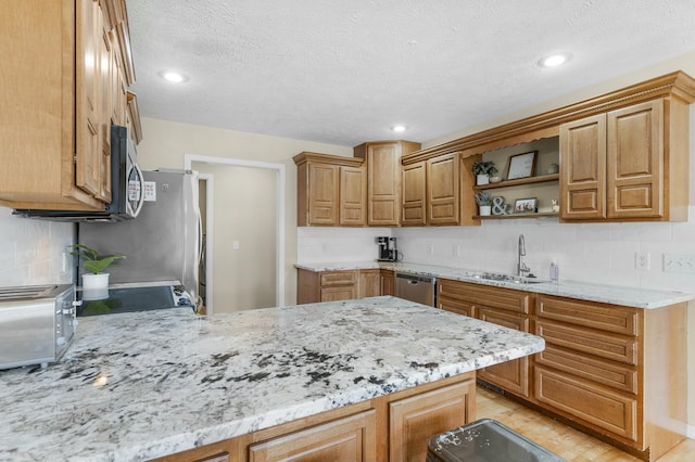 kitchen featuring a sink, light stone counters, appliances with stainless steel finishes, a peninsula, and open shelves