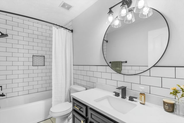 bathroom featuring visible vents, toilet, shower / bath combo, tile walls, and vanity