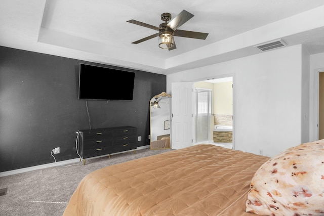 carpeted bedroom featuring a raised ceiling, baseboards, visible vents, and ceiling fan