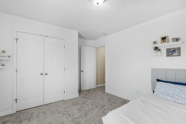 carpeted bedroom featuring a closet, baseboards, and a textured ceiling