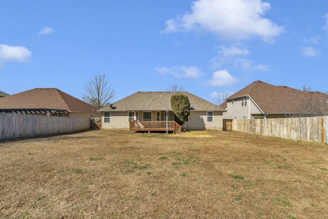 back of house with a deck, a yard, and a fenced backyard