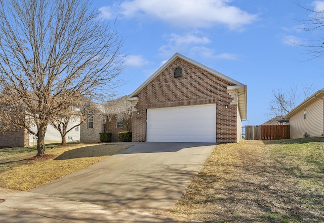 view of front facade featuring brick siding, an attached garage, driveway, and fence