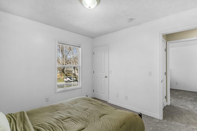 bedroom featuring baseboards, carpet, and a textured ceiling