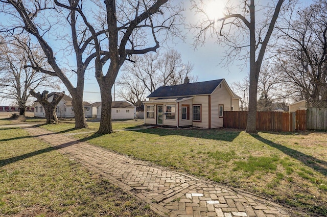 exterior space with a chimney, a yard, and fence