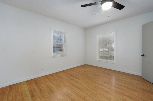 unfurnished room with baseboards, light wood-type flooring, and ceiling fan