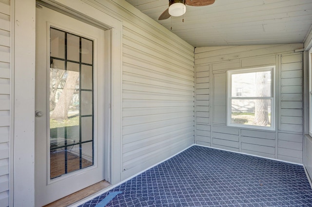 unfurnished sunroom featuring wood ceiling and ceiling fan