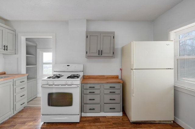 kitchen featuring white appliances, wood finished floors, and gray cabinets