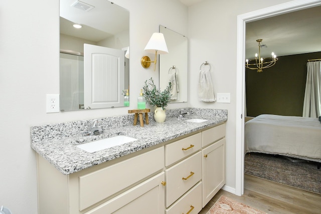 bathroom featuring a sink, visible vents, wood finished floors, and a chandelier