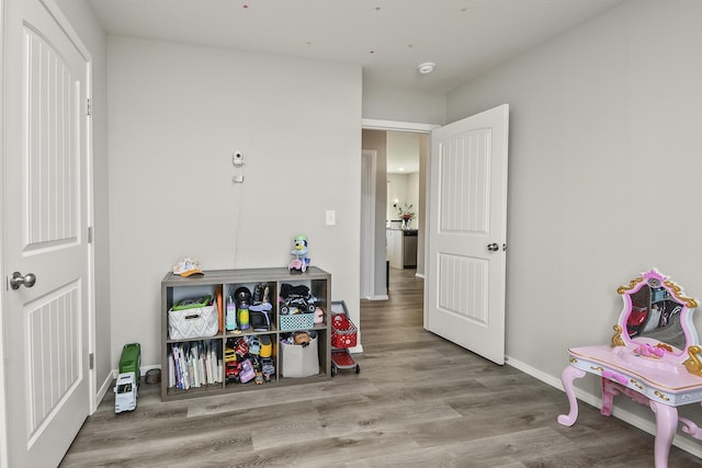 playroom featuring baseboards and wood finished floors