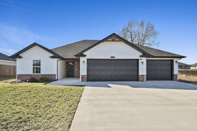 view of front facade featuring a front lawn, brick siding, a garage, and driveway