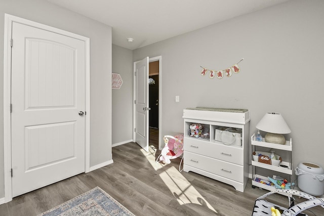 recreation room featuring baseboards and wood finished floors