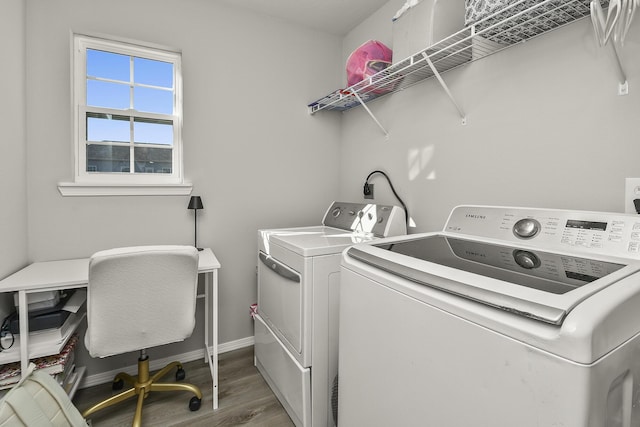 washroom with washer and dryer, baseboards, wood finished floors, and laundry area