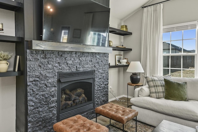 living area with wood finished floors, a fireplace, and baseboards