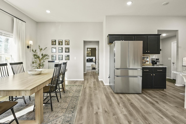 kitchen with recessed lighting, light wood-style floors, dark cabinets, and freestanding refrigerator