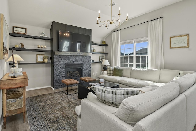 living area featuring baseboards, lofted ceiling, a fireplace, an inviting chandelier, and wood finished floors