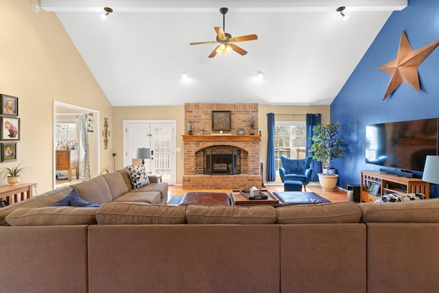 living room with baseboards, high vaulted ceiling, a brick fireplace, and ceiling fan