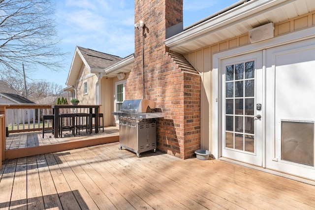 wooden deck with area for grilling and outdoor dining space