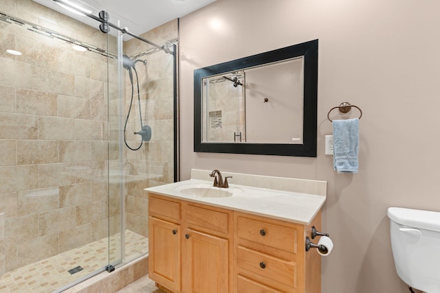 full bathroom with vanity, toilet, and a shower stall