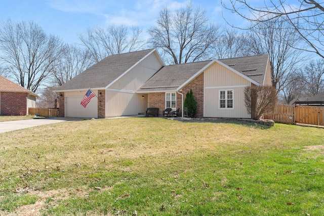 view of front of home featuring a garage, brick siding, a front yard, and fence