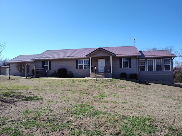 ranch-style house with metal roof and a front yard