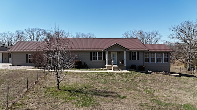 ranch-style home with metal roof and fence