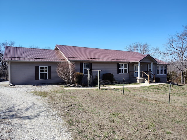 ranch-style house with a front lawn, driveway, and metal roof