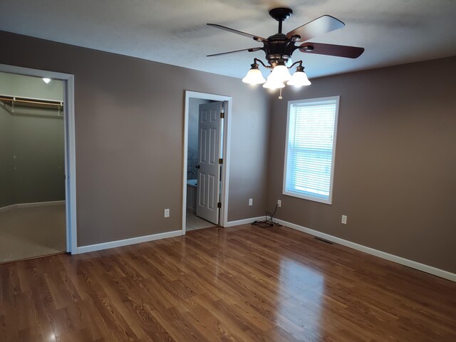 unfurnished bedroom with wood finished floors, baseboards, a closet, and ceiling fan