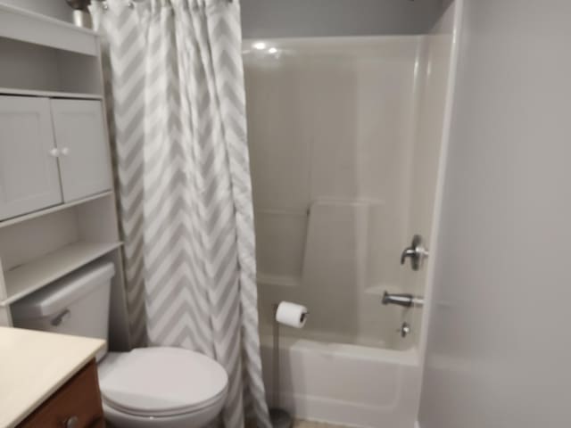 bathroom with toilet, vanity, and shower / bath combo