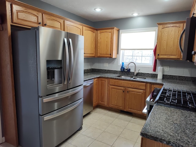 kitchen featuring dark countertops, appliances with stainless steel finishes, and a sink