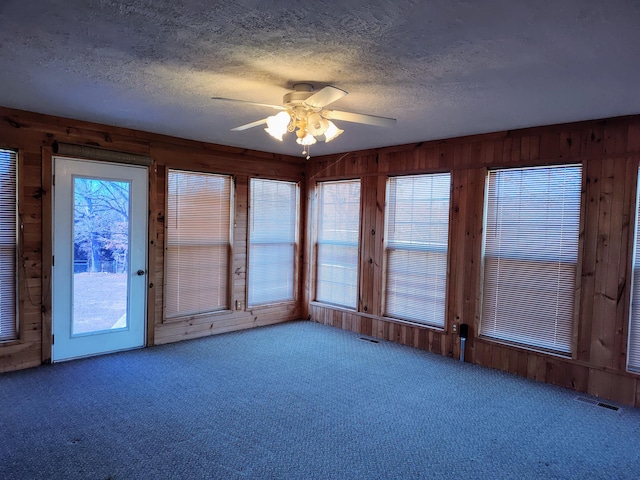 unfurnished sunroom with visible vents and ceiling fan