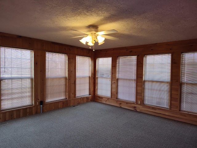 unfurnished sunroom with visible vents and a ceiling fan