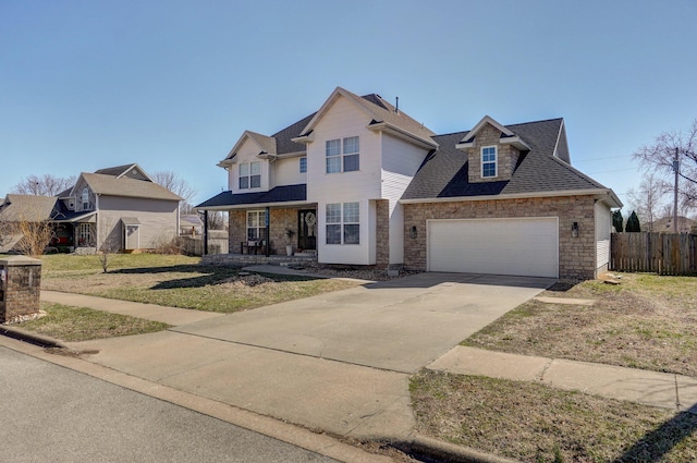 traditional home with fence, driveway, roof with shingles, stone siding, and a garage