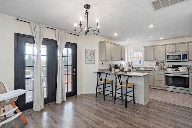 kitchen with visible vents, gray cabinets, dark wood-style flooring, and stainless steel appliances