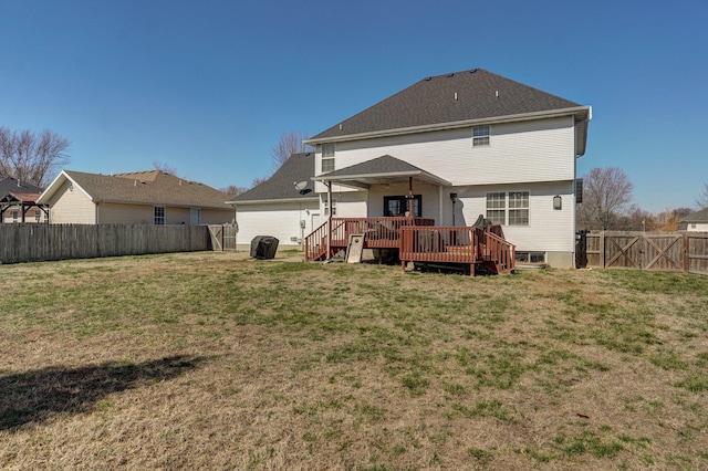 back of property with a wooden deck, a lawn, a fenced backyard, and a gate