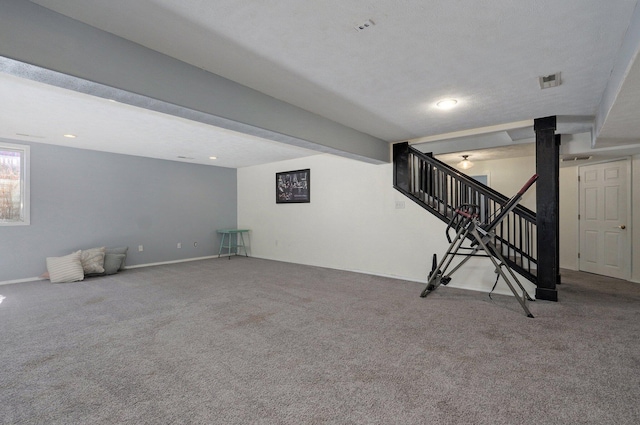 basement featuring stairs, carpet, visible vents, and baseboards