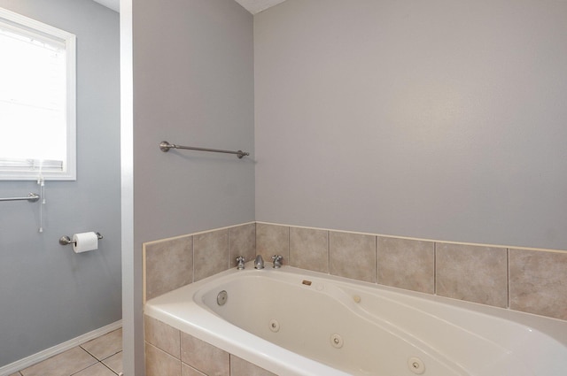 bathroom with tile patterned floors, a jetted tub, and baseboards