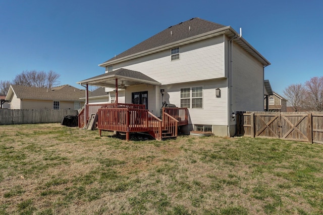 back of property featuring a wooden deck, a lawn, and a fenced backyard