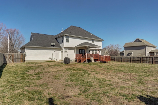 back of property with a yard, a fenced backyard, roof with shingles, and a wooden deck