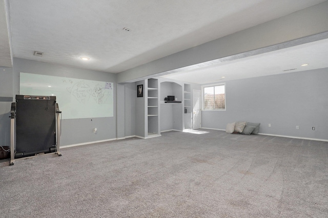 basement featuring visible vents, baseboards, and carpet floors